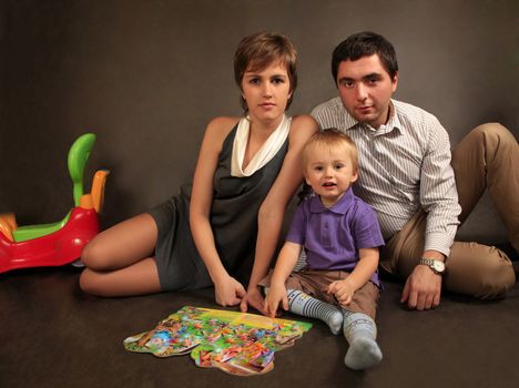 Happy young family with son in studio