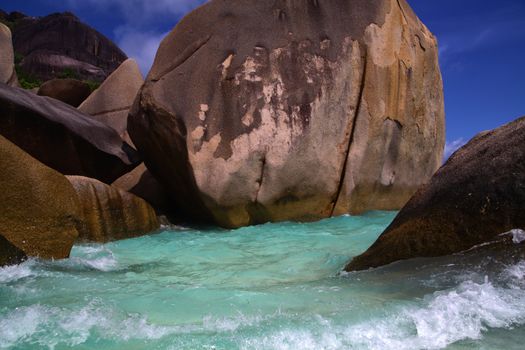 Giant boulders on the shoreline washed over by unrelenting ocean waves