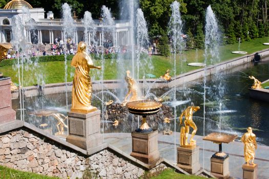 Canal with fountain and golden statues in lower park of Peterhof. Russia, St.Petersburg.