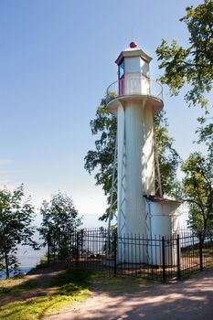 Old lighthouse on a shore in Peterhof, Russia. Sunny day and blue sky