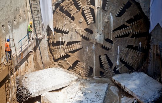 Tunnel boring machine breaking steel wall, making hole for underground