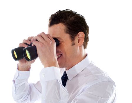 Confident male executive looking through binoculars against white background