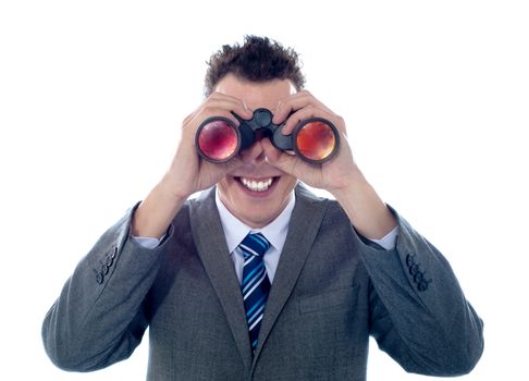 Smiling businessman looks through binoculars and seeks success. All on white background