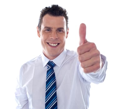 Smiling corporate man showing thumbs up against white