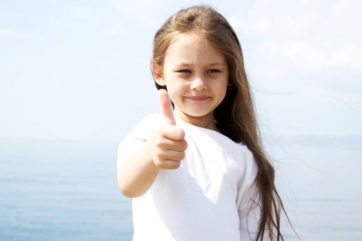 girl in a white blouse with flowing hair, hand gesture shows that all the great background of the sea