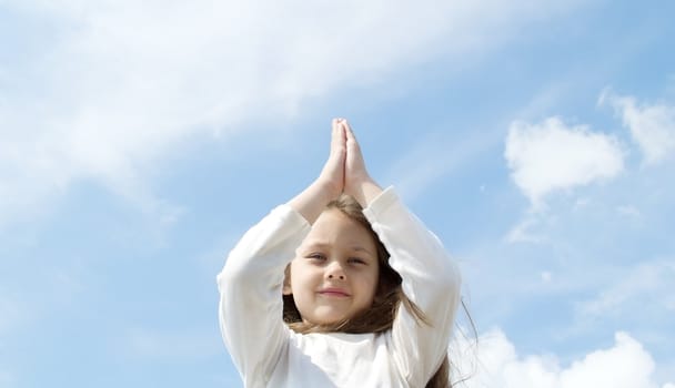 little girl meditates in the sky