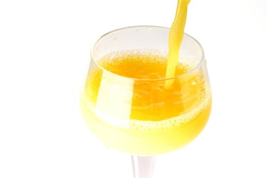 fresh brightly yellow orange juice in glass on a white background