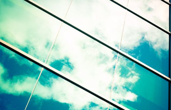 blue sky and white clouds reflected in big windows