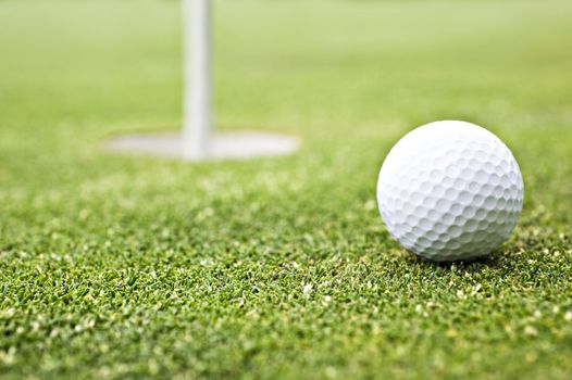 Golf ball on the green close to the hole