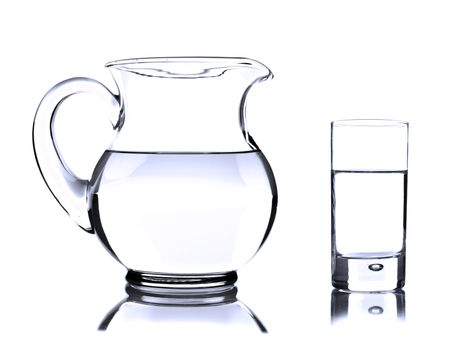 Glass jug and tumbler with water on white
