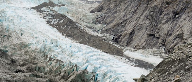 Large alpine glacier icefield melting rapidly due to global warming exposing bare rock face