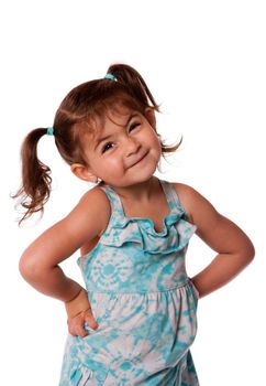 Cute little young toddler girl with attitude smirk, hands on hips and pigtails in hair, isolated.