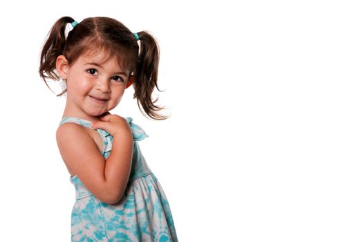 Beautiful Cute toddler girl with pigtails pointing at herself in blue summer dress, isolated. Who, me expression.