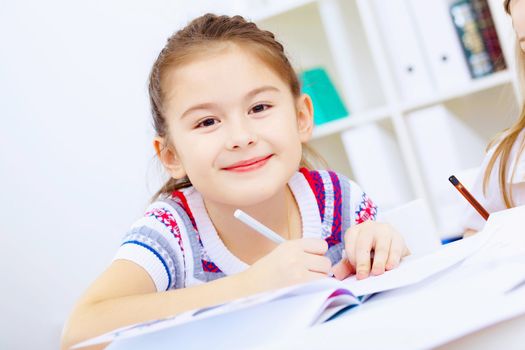 Little girl sitting and studying at home