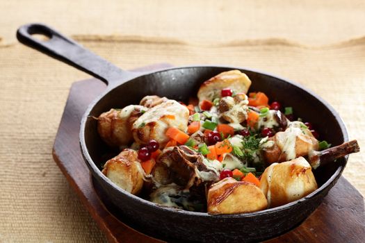 roasted potatoe with mushrooms on hot black pan