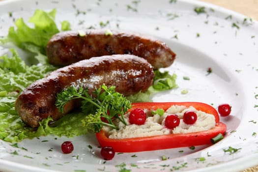 roasted sausages with pepper and berries in white pan