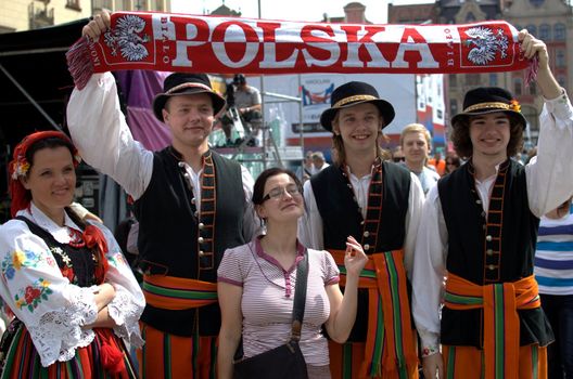 WROCLAW, POLAND - JUNE 15:  Members of Folk Dance group "Wroclaw" visit Euro 2012 fanzone. Group holds Polish football neckerchief on June 15, 2012 in Wroclaw.  