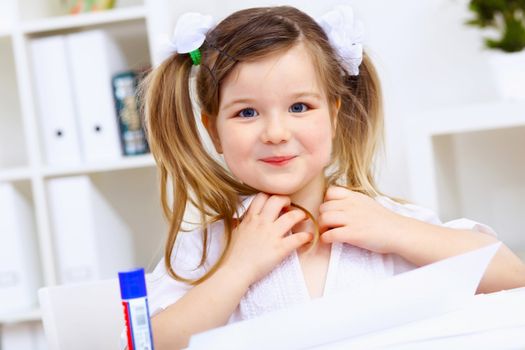 Young mother and her little girl studying together at home