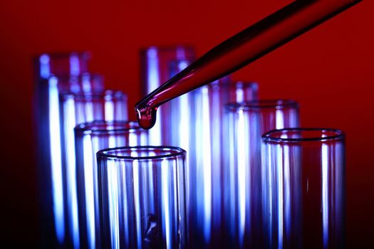 Glass chemistry tubes on a colour background