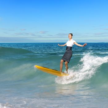 Image of young business person surfing on the waves of the ocean