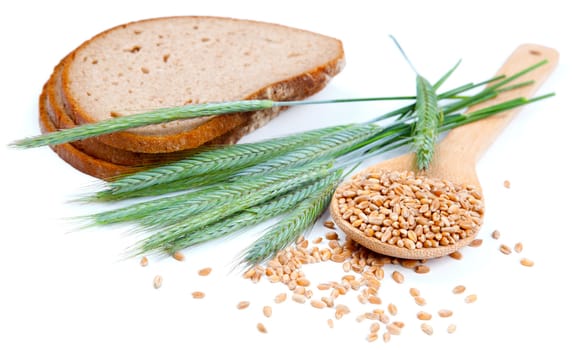 tasty baked bread with ears and wheat grain, isolated on a white background