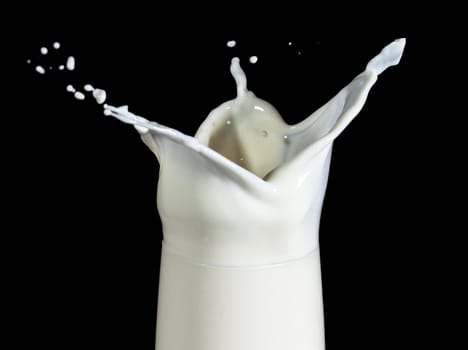 Milk with Splash in Glass, on black background