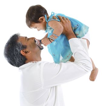 Mature traditional Indian father raise her baby girl up, isolated on with background