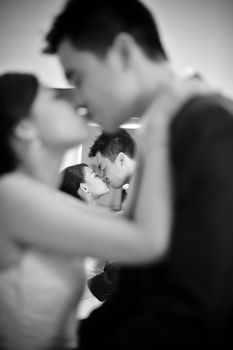 Kissing couple groom and bride enjoying dancing in monotone