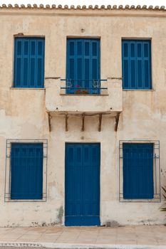 Locked old house with blue door and shutters in Greece, Europe.