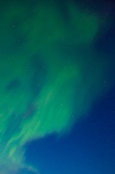 Clear night sky with lots of stars and dancing northern lights (Aurora borealis).