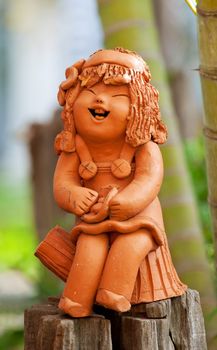 Pottery statuette of happy girl.