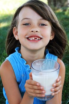 Little girl drinking milk with a milk mustache. Shallow depth of field with selective focus on little girl's face.