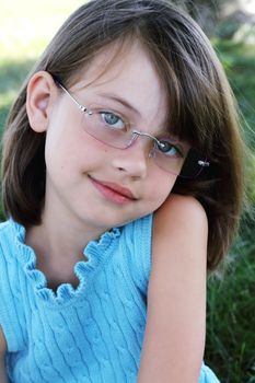 Little girl wearing glasses and looking directly at viewer. Shallow depth of field with selective focus on child's face.
