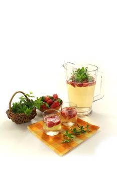 May wine with fresh strawberries and woodruff on a light background