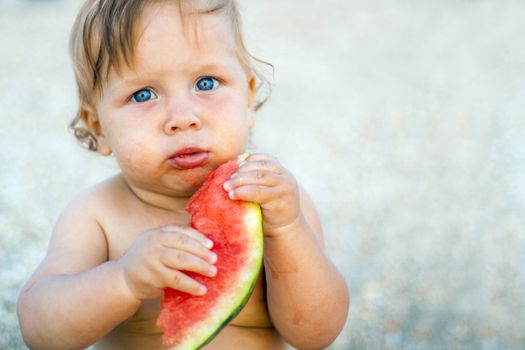 little baby eating watermelon outdoors