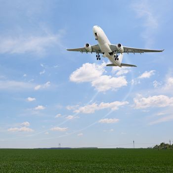 Passenger aircraft taking off over the fields