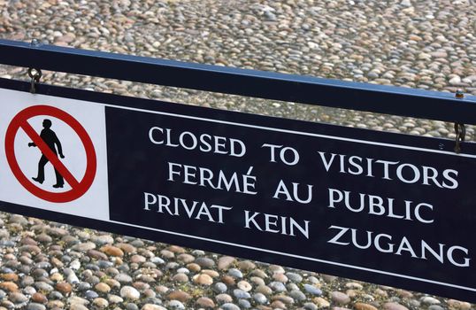 Closed To Visitors Road sign written in different languages.