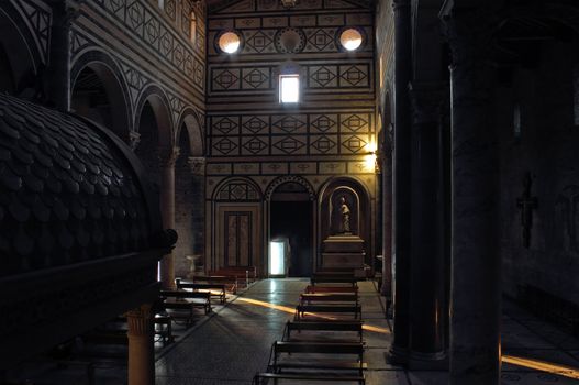 San Miniato al Monte in Florence church interior with warm light coming through the door and windows.