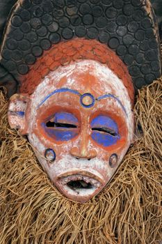 Traditional Tribal African Mask with straw beard and blue colored eyes.