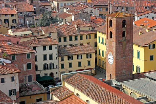 View of the historic part of Lucca in Italy, with an old clock tower and the narrow streets.