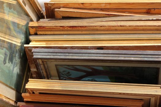 A bunch of old frames with some artworks on a saturday market. 