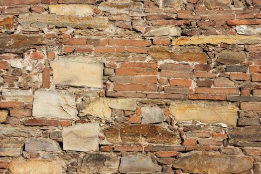 Stone and bricks in this colorful ancient church wall as a background.