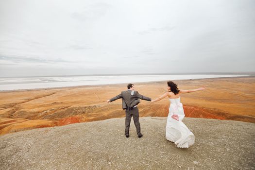 bride and groom on the mountain ready to jump