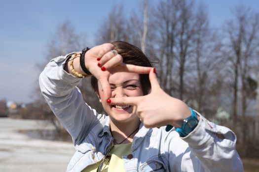 Young Photographer. Portrait of beautiful young girl make picture frame with her fingers