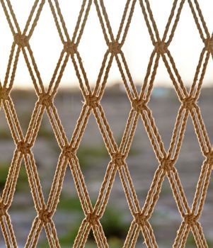 Texture of horizon line falling through a hammock style rope chair hanging from the ceiling on a balcony. Generic shot location hotel near Dwarka, Gujarat, India