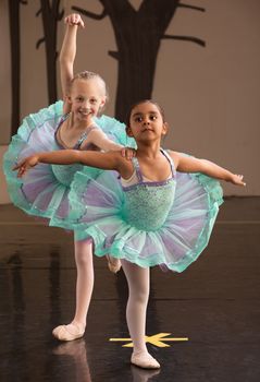 Two ballet students in fancy dresses posing together 
