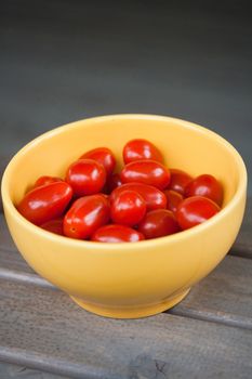 Small cherry tomatoes in yellow bowl