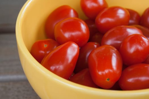 Small cherry tomatoes in yellow bowl