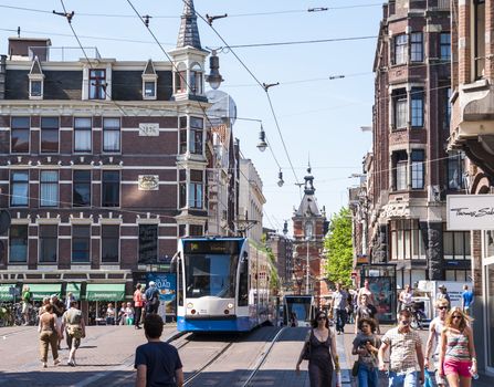 AMSTERDAM, HOLLAND - MAY 27: Tram running in the city centre amongst pedestrians. May 27, 2012 in Amsterdam. The tram network comprises 16 lines and covers 213 kilometres.