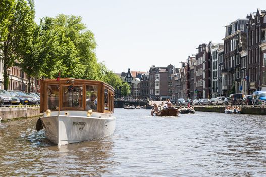 AMSTERDAM, HOLLAND - MAY 27: Private boat in one of the main canals in the city centre. May 27, 2012 in Amsterdam.